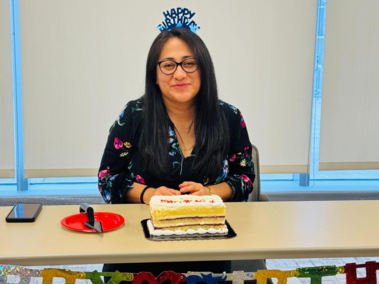 Birthday celebration at a table with cake, decorations, and a "Happy Birthday" headband.
